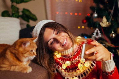 woman taking cell phone photo with cat